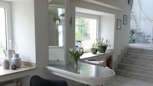 A modern kitchen with a dining area, large windows, and a staircase leading to an upper floor. - Haus Erholung (Cochem)