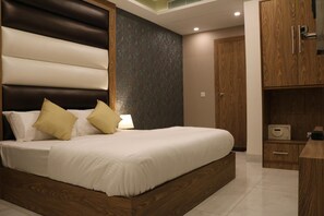 A modern bedroom with a large bed, wooden headboard, and built-in wardrobe.