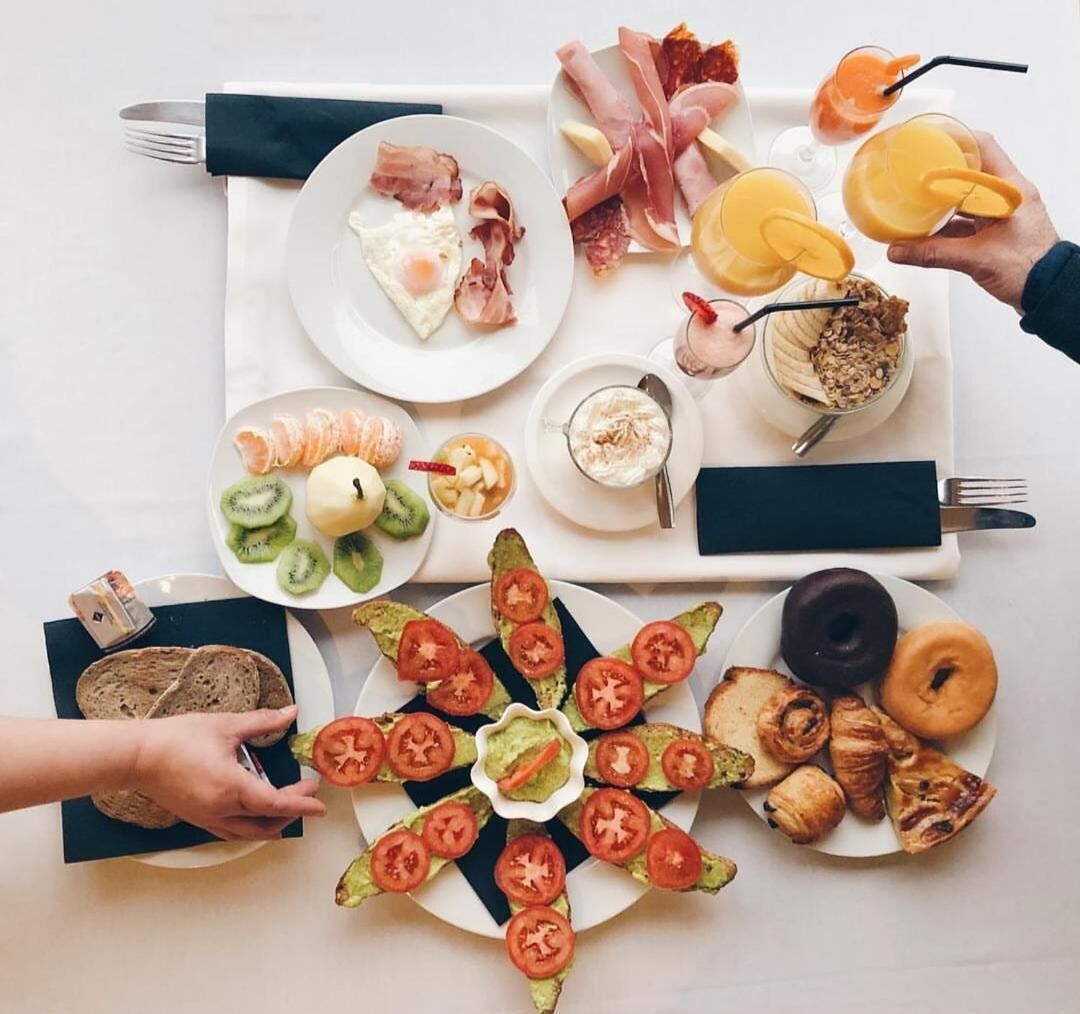 A breakfast spread with various foods and drinks on a table.
