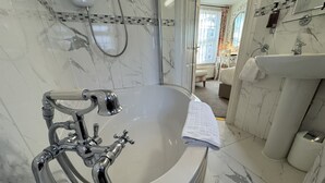 Een badkamer met een groot bad, een douche en een toilet.