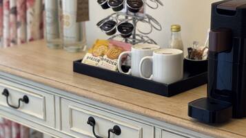 A coffee station with a tray of coffee cups, a coffee maker, and a bottle of water.