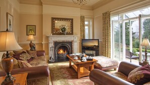 Un salón acogedor con chimenea, asientos cómodos y un ventanal con vistas al exterior.