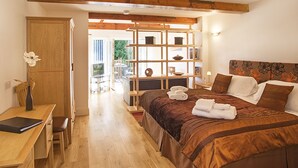 Un dormitorio con una cama de madera, un escritorio con una silla, un televisor y una estantería.