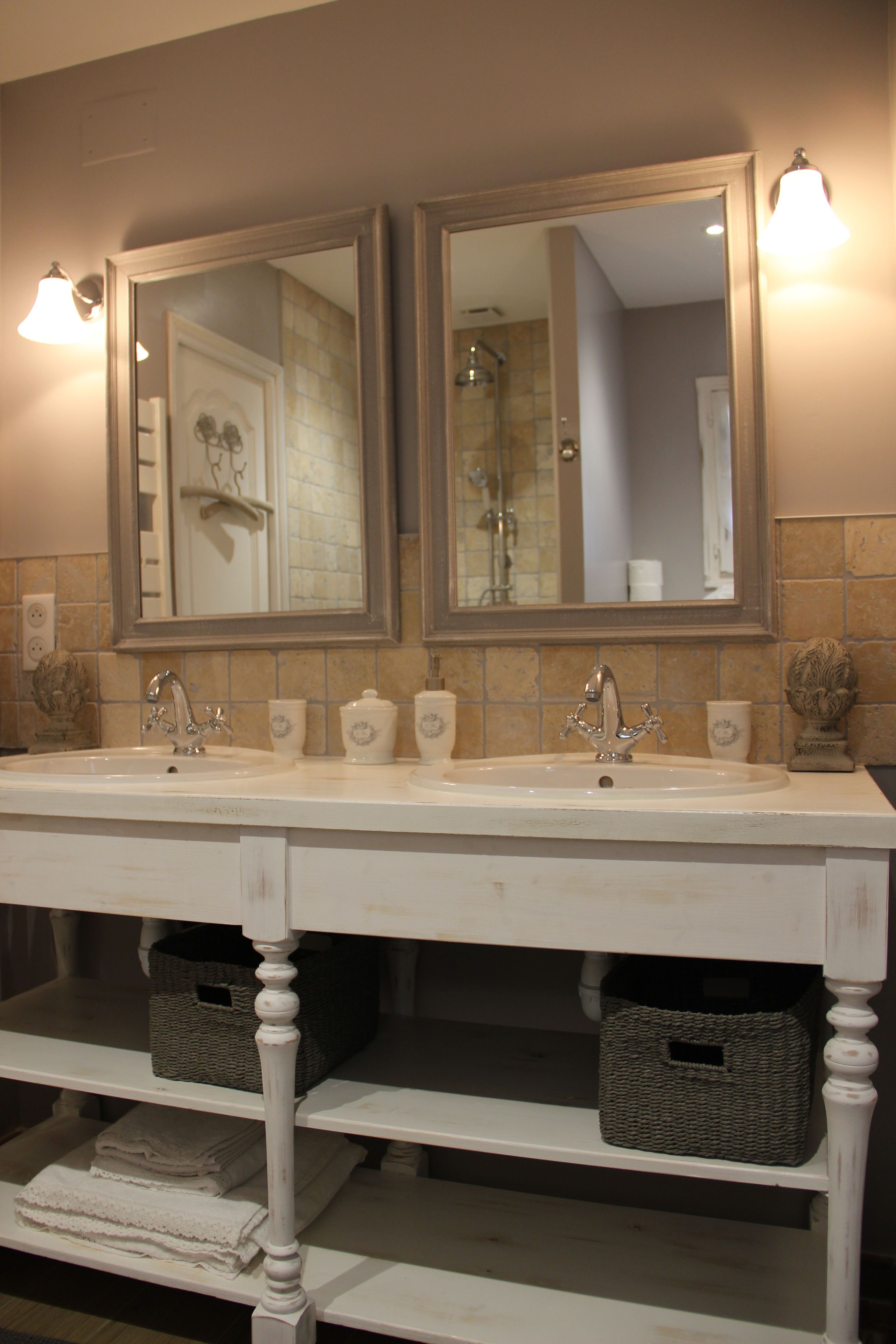 Une salle de bain avec un double lavabo, deux miroirs et un porte-serviettes.