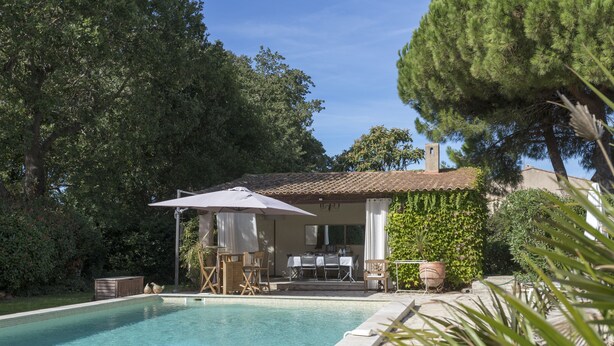 A swimming pool with a patio area, outdoor furniture, and a building with a tiled roof. - La Bastide du Bouchou (Six-Fours-les-Plages)