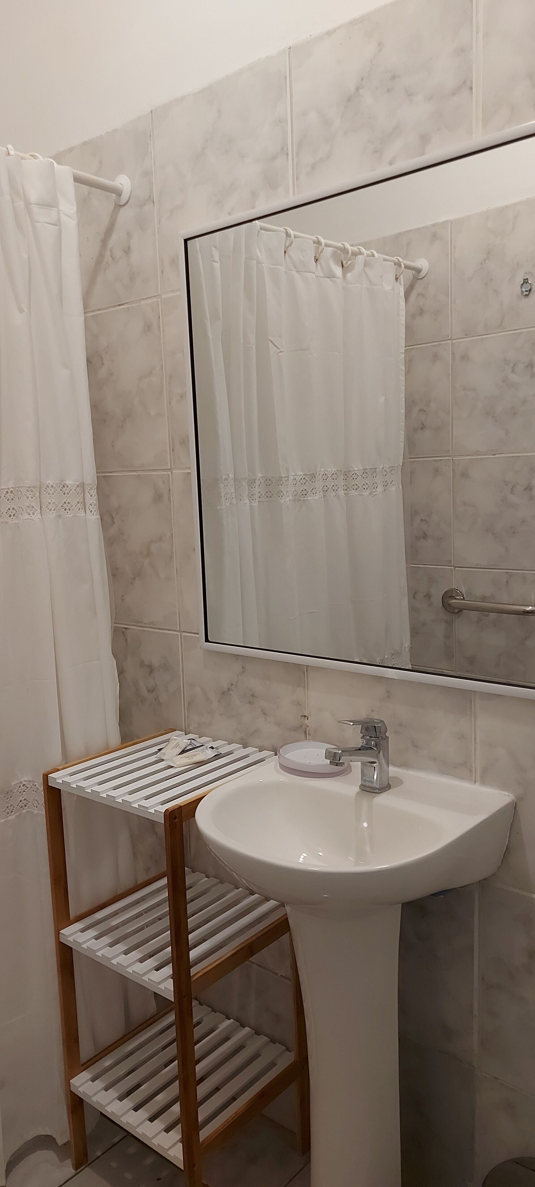 A bathroom with a white sink, a mirror, and a shower curtain.