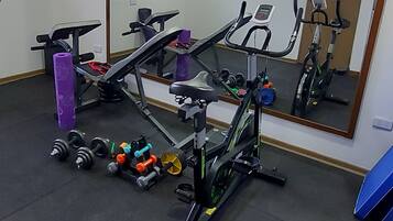A gym with exercise equipment, a mirror, and a window.