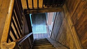 Eine hölzerne Wendeltreppe mit Handlauf, die zu einer unteren Ebene führt.