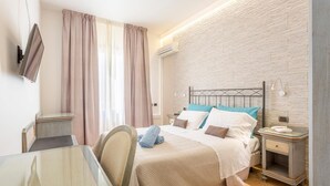 A hotel room with a bed, bedside tables, a TV, and a window with curtains. - Hotel Ristorante Trinacria (San Vito Lo Capo)