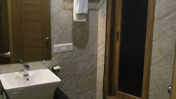 Un baño con lavabo, espejo, toallero y puerta.