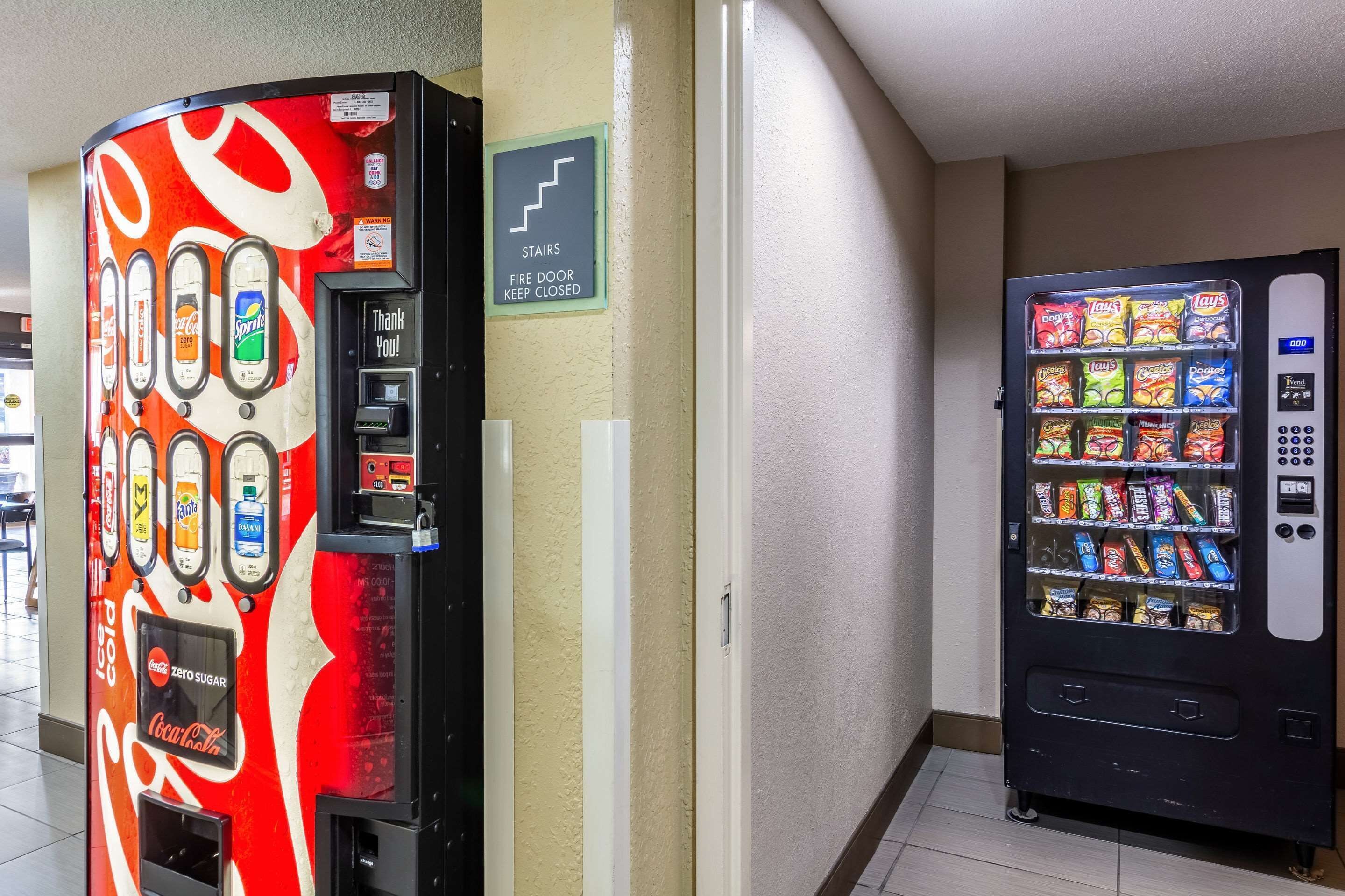 Duas máquinas de venda automática, uma com o design da Coca-Cola e outra com petiscos.