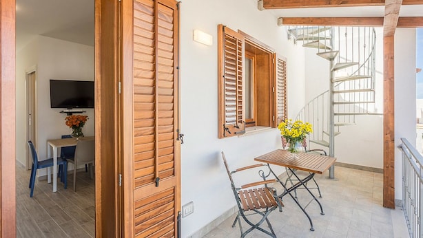 Ein Balkon mit Holzhörnern, einem Tisch mit Stühlen und einer Wendeltreppe.