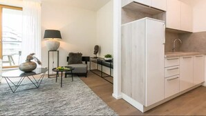 A modern kitchen with white cabinets and a built-in oven. - Flawless Apartments Pod Děkankou (Prague)
