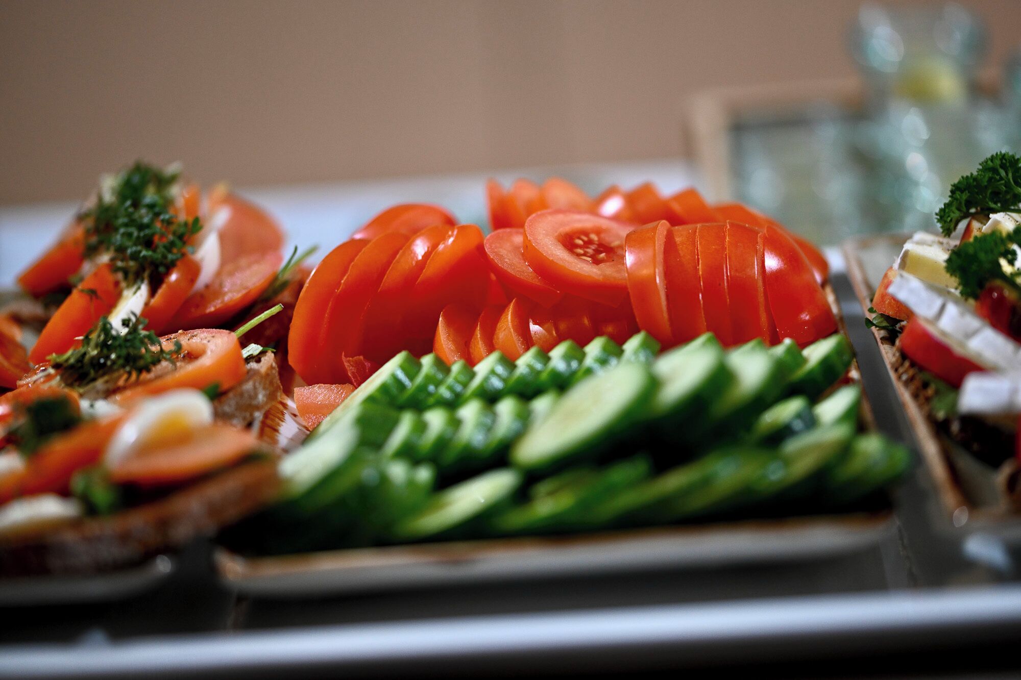 Un plat garni de tomates, de concombres et d’autres légumes coupés en tranches.