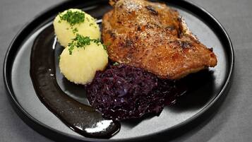 Un plato con carne, puré de papas y col roja.