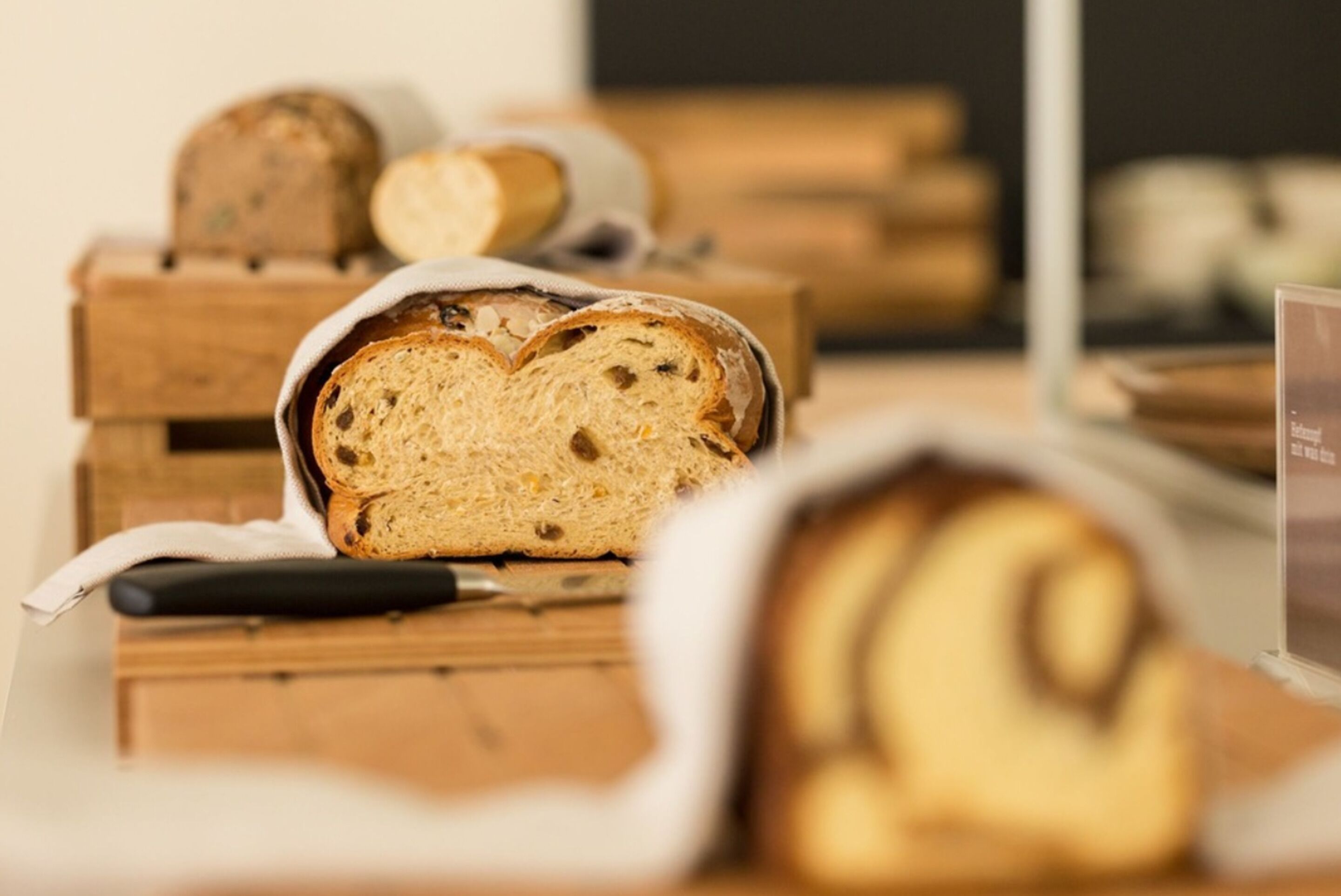 A loaf of bread on a wooden surface with a knife.