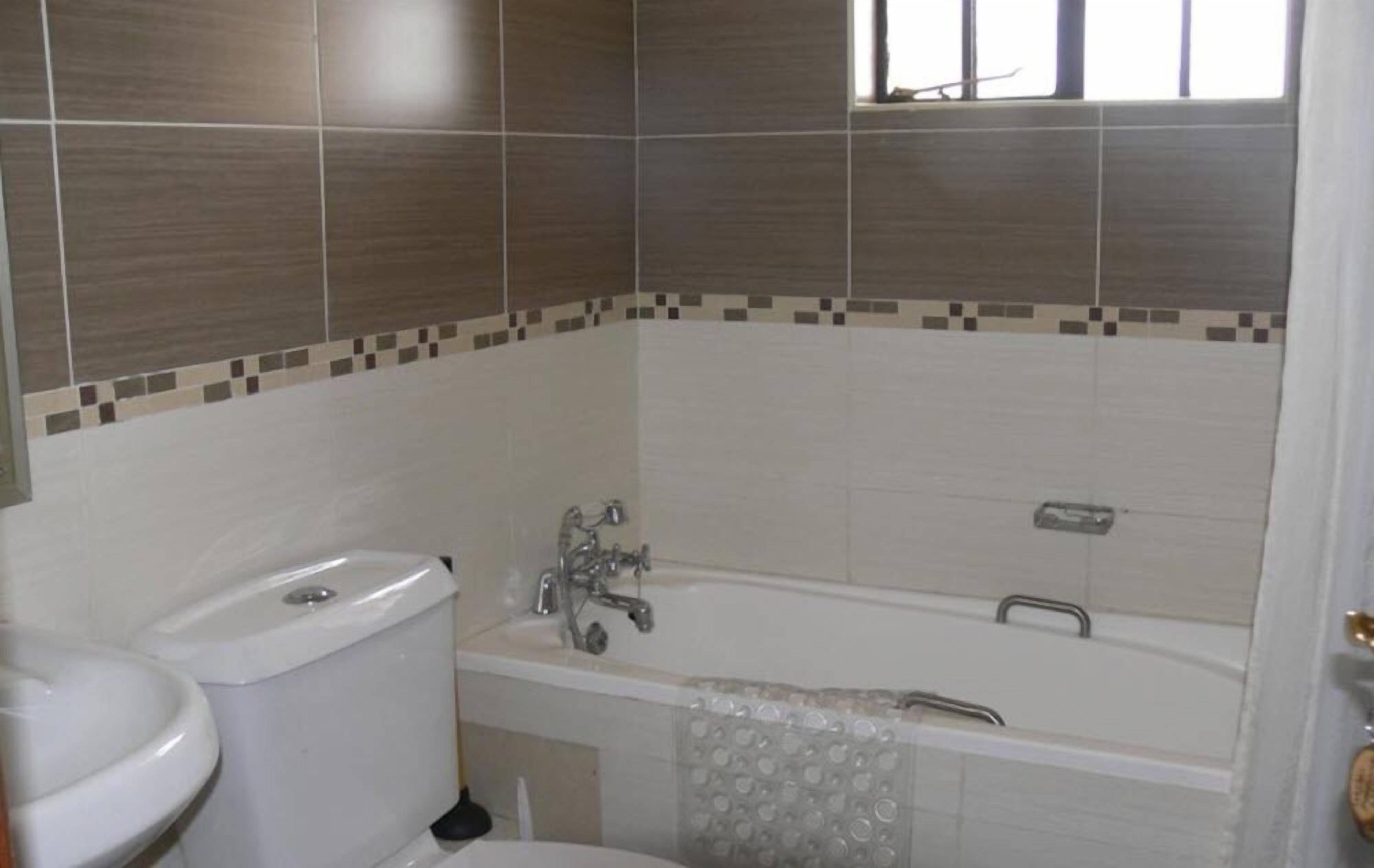 A bathroom with a toilet, sink, and bathtub.