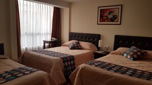 A hotel room with two beds, a nightstand, a lamp, and a painting on the wall. - Hotel Santa Beatriz (Cusco)