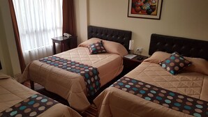 A hotel room with two beds, each with a polka dot bedspread and matching pillows. There is a nightstand with a lamp and a phone. A painting is on the wall above the beds. - Hotel Santa Beatriz (Cusco)