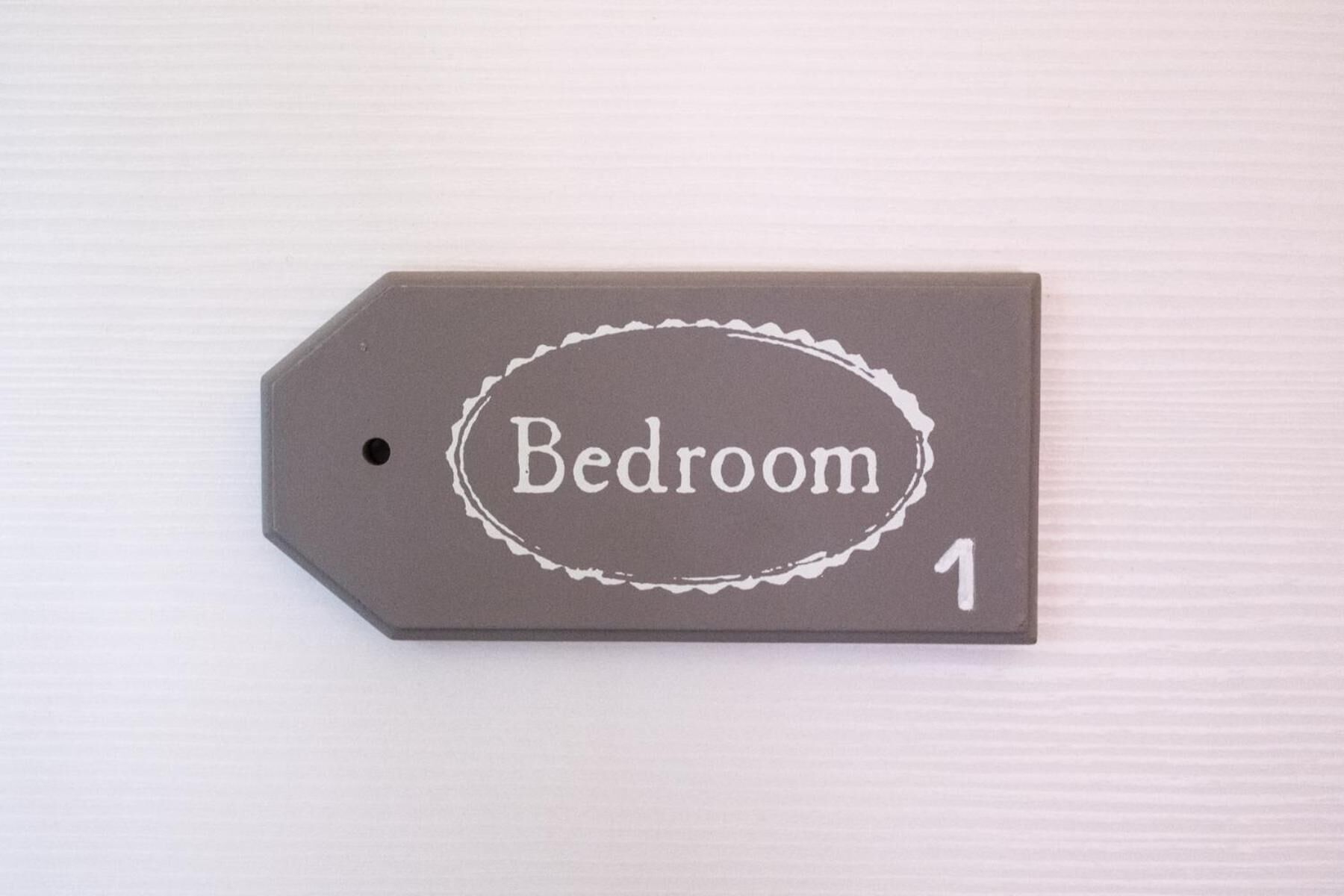 A tag labeled 'Bedroom 1' on a textured surface.