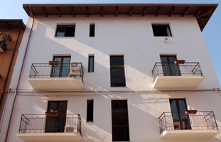 Un edificio de varios pisos con balcones, ventanas y techo plano.