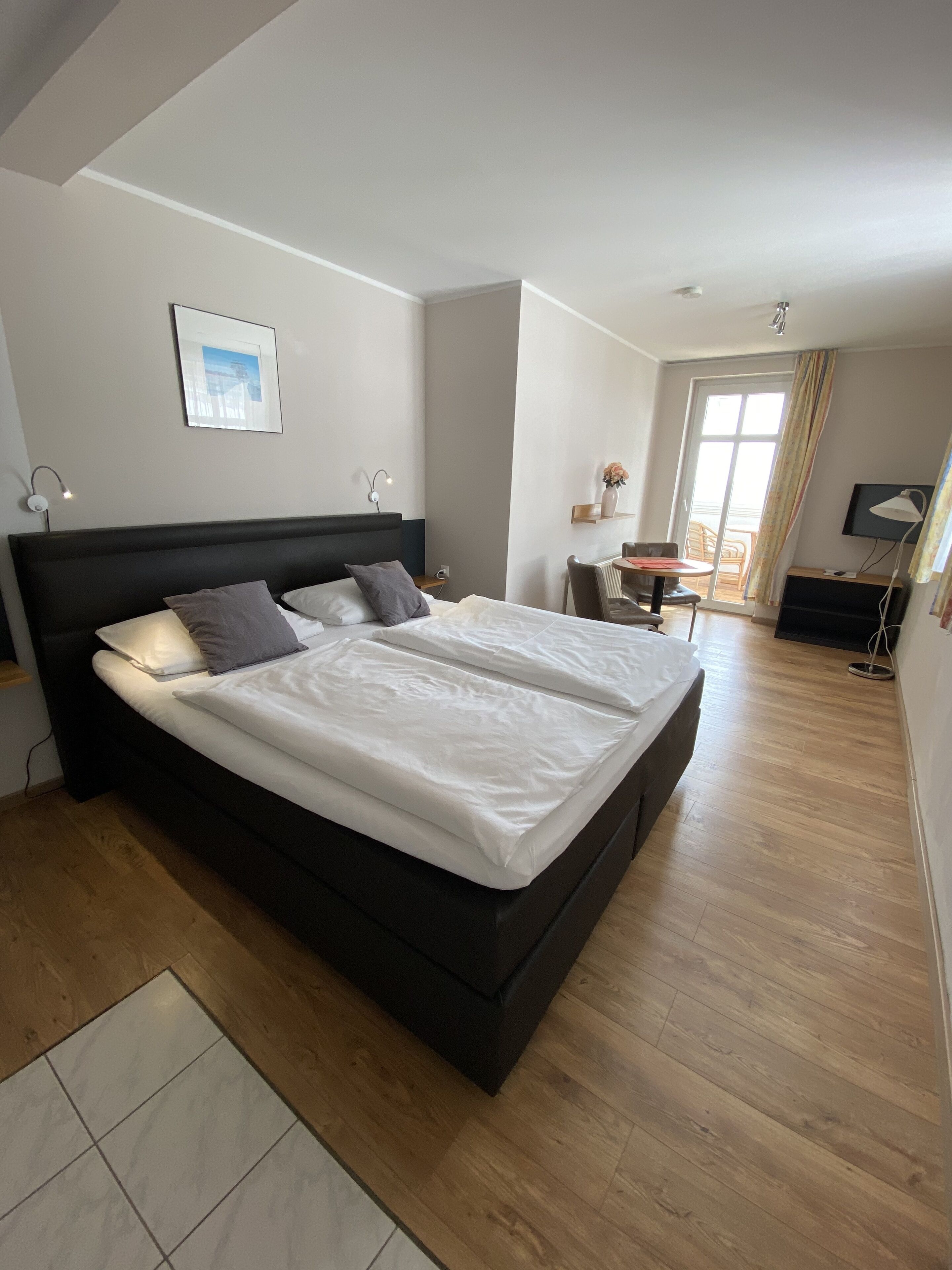 Una camera da letto moderna con un letto grande, una scrivania e una sedia.