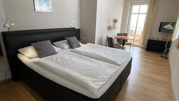 Una camera da letto moderna con un letto grande, una scrivania e una sedia.