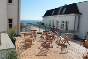 A wooden deck with outdoor seating and a view of the sea. - Pension Villa Elisabeth (Sassnitz)