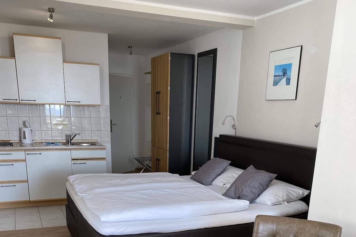 Une chambre d’hôtel moderne équipée d’un lit, d’une table à manger et d’une kitchenette.
