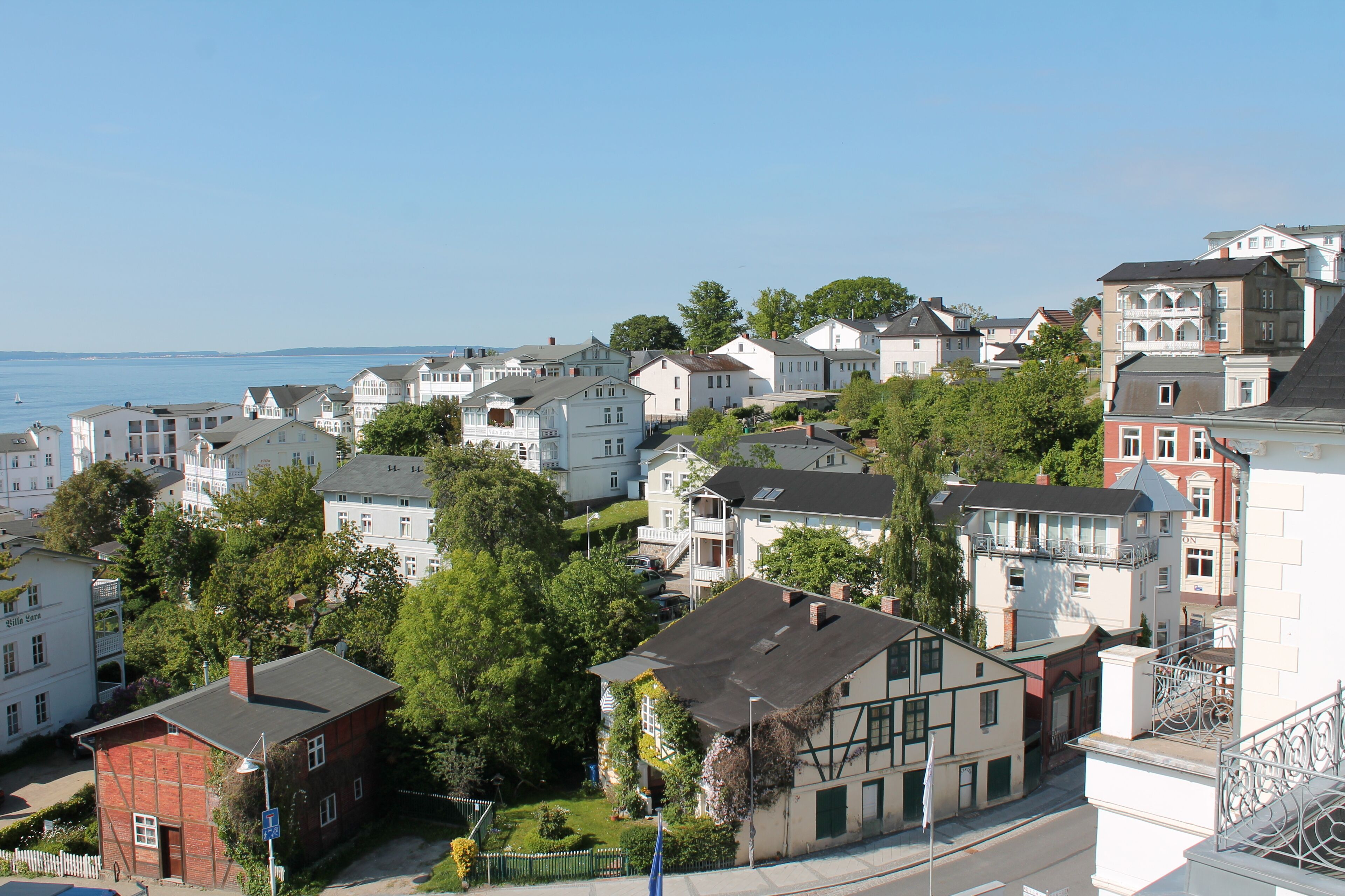Een woongebied aan de kust met diverse huizen, sommige met balkons en andere met grote ramen.