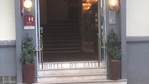 La entrada del Hotel du Gave, con una escalera que conduce a la puerta, un cartel con el nombre del hotel y dos macetas a ambos lados de la entrada.