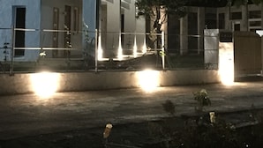 Ein modernes Gebäude mit weißer Fassade und großen Fenstern, beleuchtet durch Außenbeleuchtung.