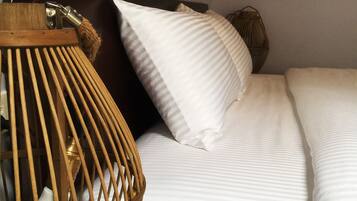 Una cama con ropa de cama blanca y cabecera de madera.