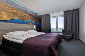 Une chambre d’hôtel avec un grand lit, une chaise, une fenêtre avec des rideaux et une fresque représentant un paysage sur le mur.