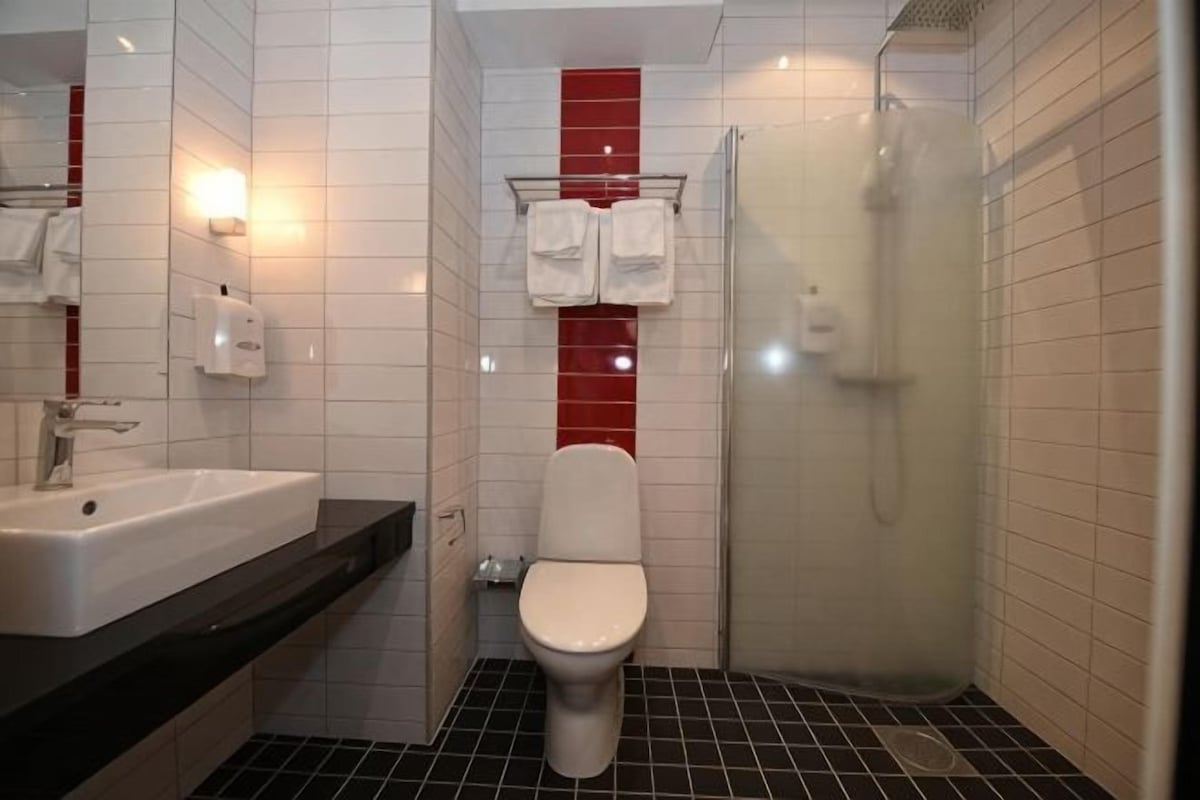 A bathroom with a sink, toilet, and shower.