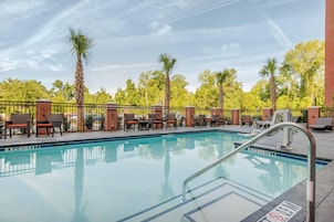 Una piscina al aire libre, sillones reclinables de piscina