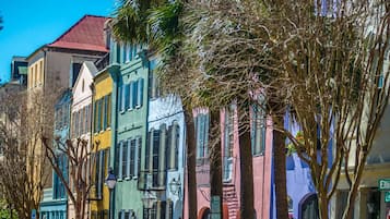 A row of colorful buildings with a mix of architectural styles, including a building with a red roof and another with a green facade.