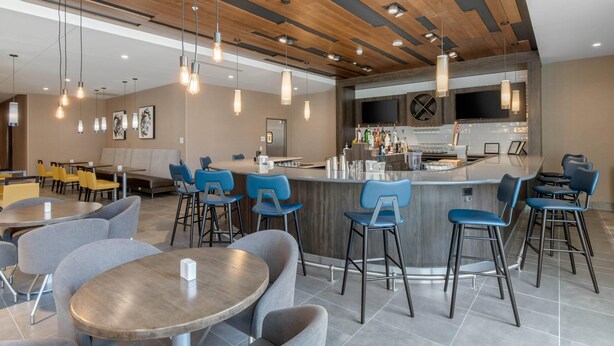 Un espace bar moderne avec un plafond en bois, des tabourets de bar et un comptoir.