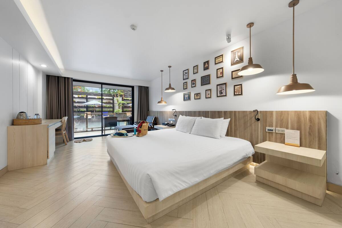 Een moderne hotelkamer met een groot bed, een bureau en uitzicht op de omgeving.