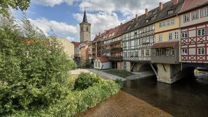 A historic town with traditional half-timbered buildings, a church tower, and a river. - Waldhotel Berghof (Luisenthal)