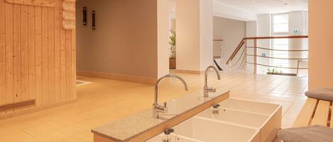 A modern bathroom with a long, rectangular sink and a wooden wall.