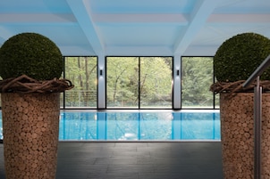 Una piscina techada, sillones reclinables de piscina