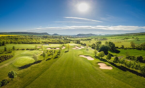 A golf course with sand bunkers, trees, and a clear sky. - Waldhotel Berghof (Luisenthal)