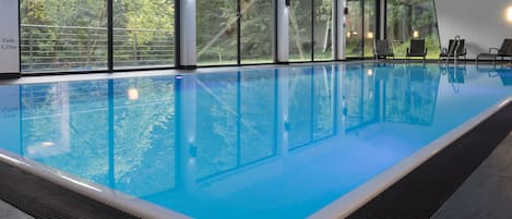 Een binnenzwembad en ligstoelen