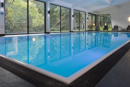 Una piscina techada, sillones reclinables de piscina