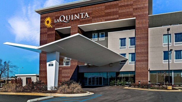 A La Quinta hotel with a modern design, featuring a prominent entrance and a parking area. - La Quinta Inn & Suites by Wyndham Tuscaloosa University (Tuscaloosa)