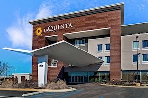 Hotel La Quinta con diseño moderno, que presenta una entrada destacada y un área de estacionamiento.