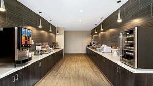 A modern kitchen with dark wood cabinets, stainless steel appliances, and pendant lighting. - La Quinta Inn & Suites by Wyndham Tuscaloosa University (Tuscaloosa)