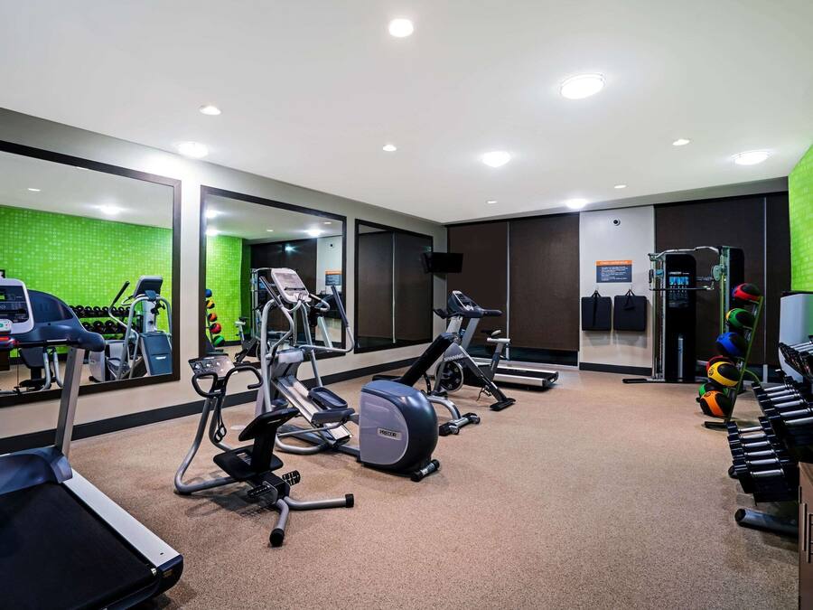 A gym with treadmills, elliptical machines, and weight machines.