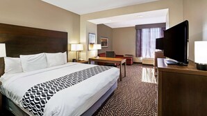 A hotel room with a large bed, a desk, a television, and a window with curtains. - La Quinta Inn & Suites by Wyndham Tuscaloosa University (Tuscaloosa)